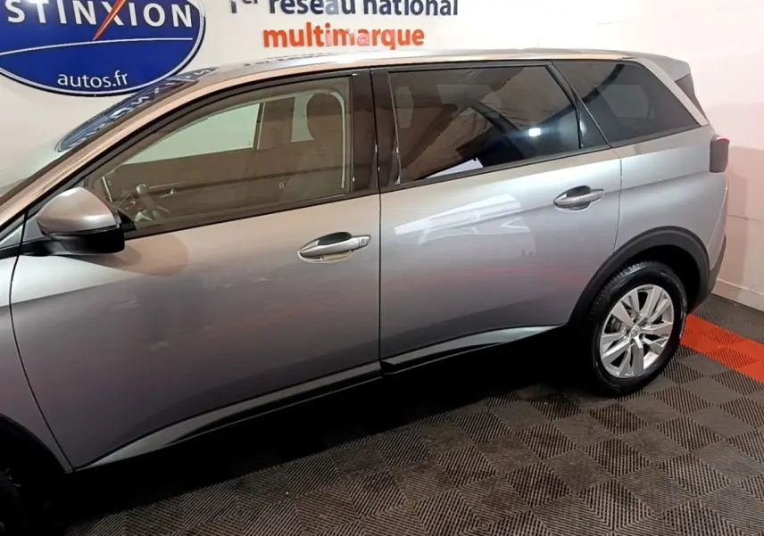 Profil côté gauche du Peugeot 5008 gris foncé 2020 dans un showroom avec rétroviseurs électriques et jantes alliage.