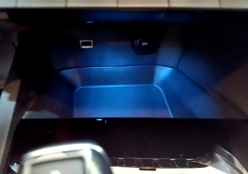 Gros plan sur la prise 12V et port USB dans le rangement avant du Peugeot 5008 gris foncé, version 2020.