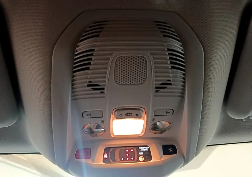 Vue intérieure du plafonnier avant du Peugeot 5008 gris foncé avec éclairage et commandes intégrées.