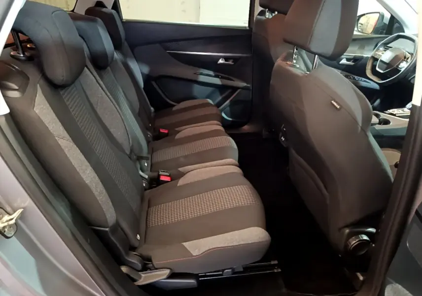 Vue intérieure côté gauche sur les sièges arrière tissu gris du Peugeot 5008 2020, avec partie avant et volant visibles.