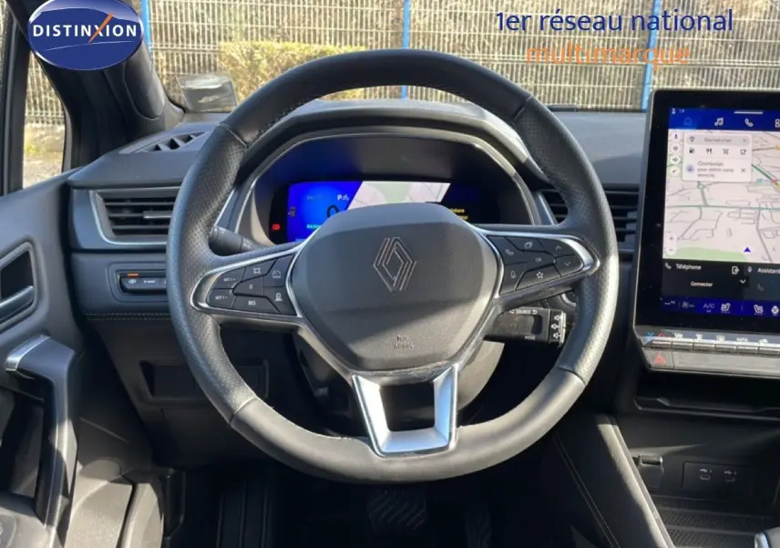 Vue intérieure centrée sur le volant cuir du Renault Symbioz 2025 avec tableau de bord digital et écran tactile.