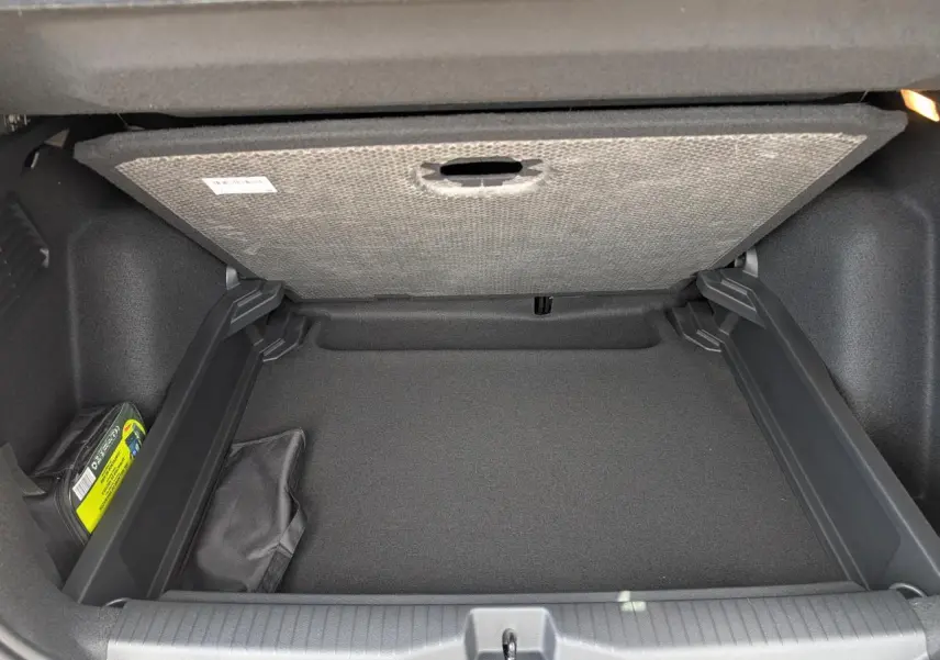 Coffre ouvert vu de face avec plancher relevé, intérieur noir, sans chargement visible.
