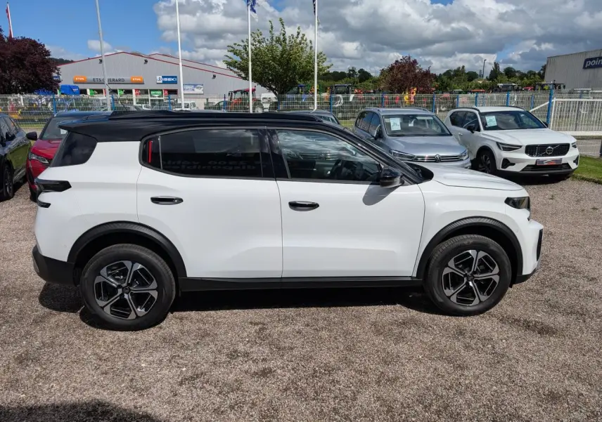 Vue de profil côté gauche d'un Citroën C3 Aircross blanc avec toit noir et jantes alliage 17 pouces.