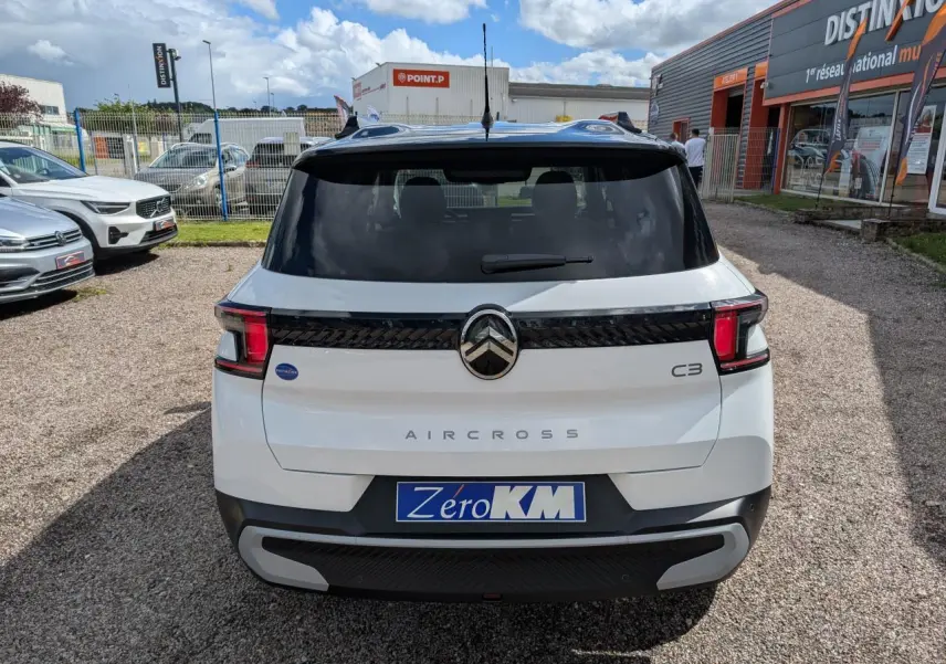 Vue arrière d'une Citroën C3 Aircross blanche avec toit noir, feux arrière LED et logo central chromé.