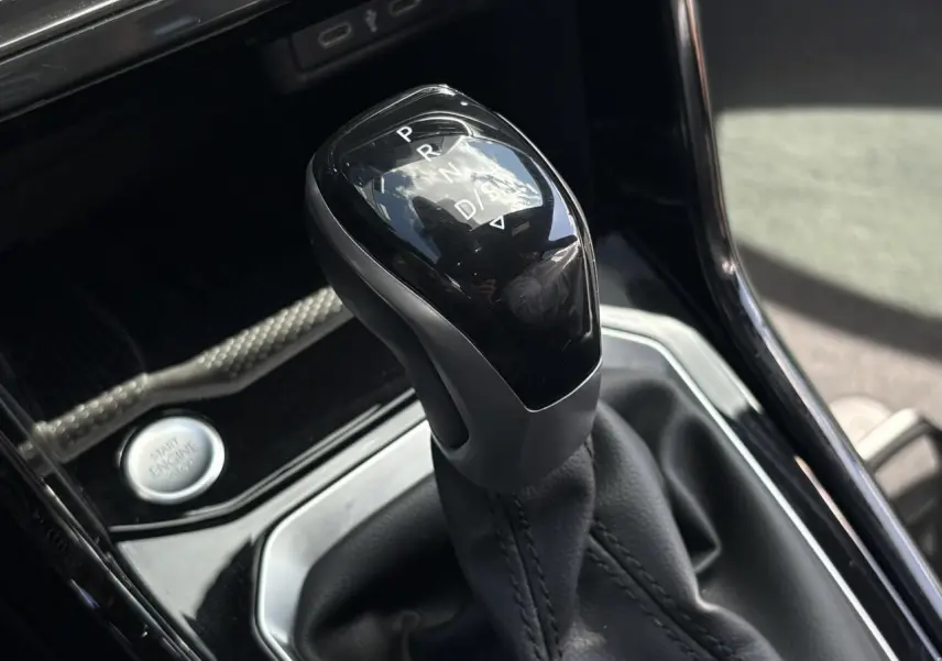 Le levier de vitesses automatique noir brillant du Volkswagen T-Roc 1.5 TSI R-Line, vue rapprochée intérieure.