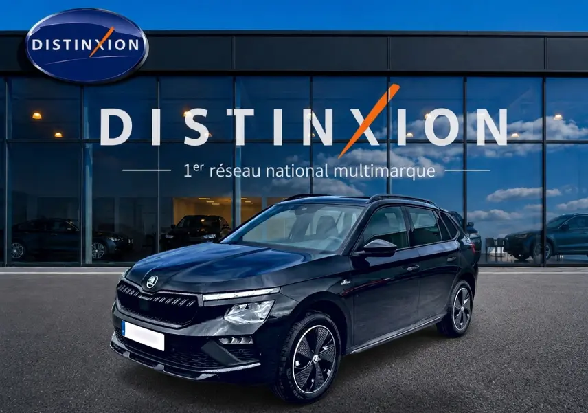 Vue 3/4 avant gauche d’un Skoda Kamiq noir Monte Carlo avec jantes alu distinctives, devant une vitrine Distinxion.
