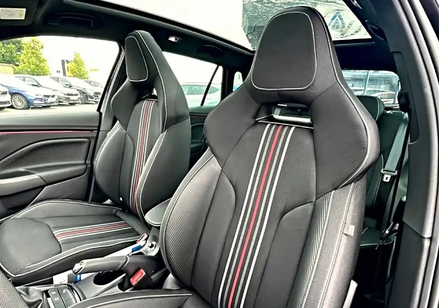 Vue intérieure des sièges avant sport noirs avec surpiqûres blanches et bandes rouges du Skoda Kamiq Monte Carlo 2026.