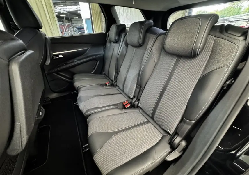 Vue latérale intérieure sur la deuxième rangée de sièges gris et noirs du Peugeot 5008 noir, version 2022 Allure Pack.