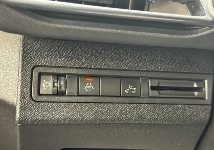 Gros plan sur les commandes noires du tableau de bord du Peugeot 5008, avec bouton d’alerte de franchissement de ligne activé.