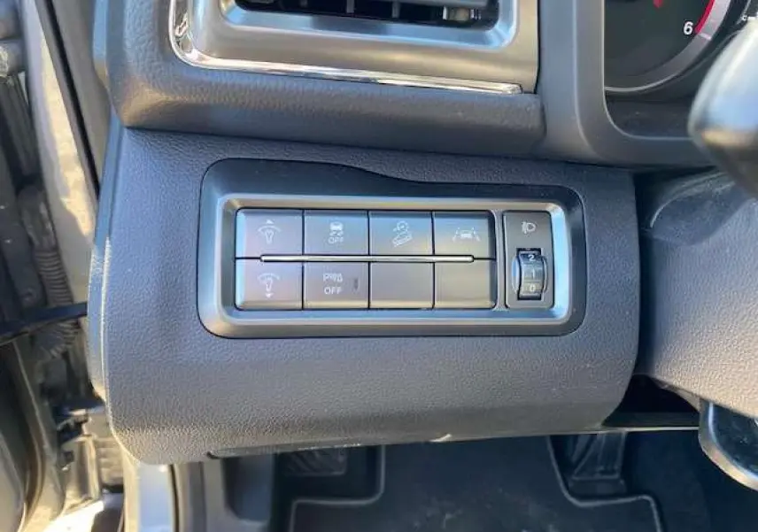 Panneau de commandes latéral gauche du tableau de bord du SsangYong Tivoli gris foncé 2021, avec boutons de réglage et molette.