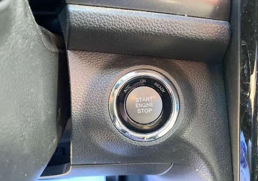 Bouton start/stop moteur en gros plan sur tableau de bord noir du SsangYong Tivoli gris foncé 2021 version Pop.