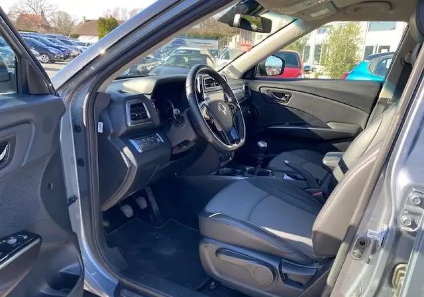 Intérieur du SsangYong Tivoli gris foncé 2021, vue côté conducteur avec sièges tissu et volant multifonction.
