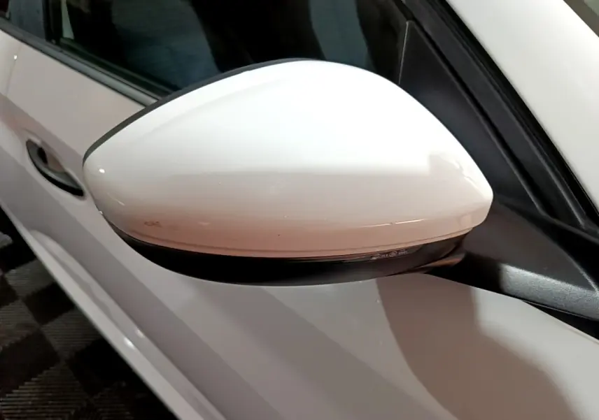 Gros plan sur le rétroviseur côté gauche blanc de la Peugeot 208 1.5 BlueHDi 100 S&S Premium 2021.