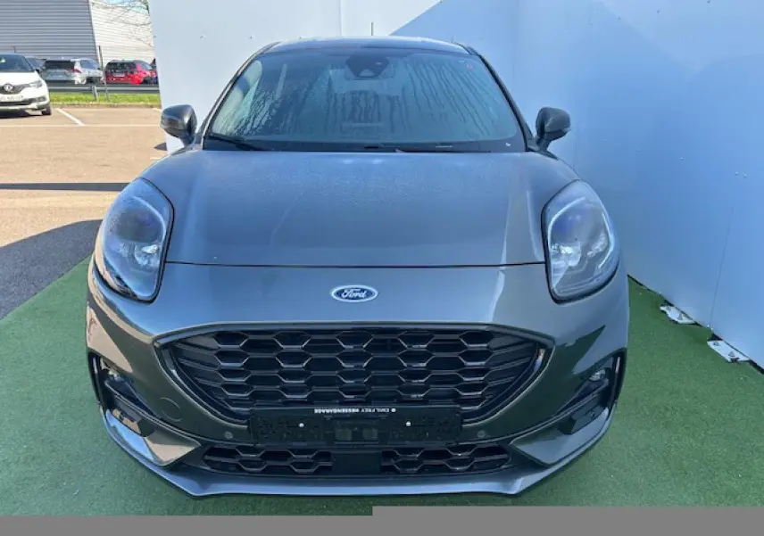 Vue avant rapprochée d’un Ford Puma gris Magnetic 2023 avec calandre noire et phares arrondis.