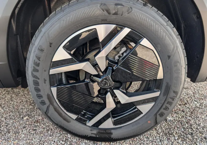 Gros plan sur la jante alliage 17'' bi-ton noir et argent du côté gauche du Peugeot 2008 blanc 2026.