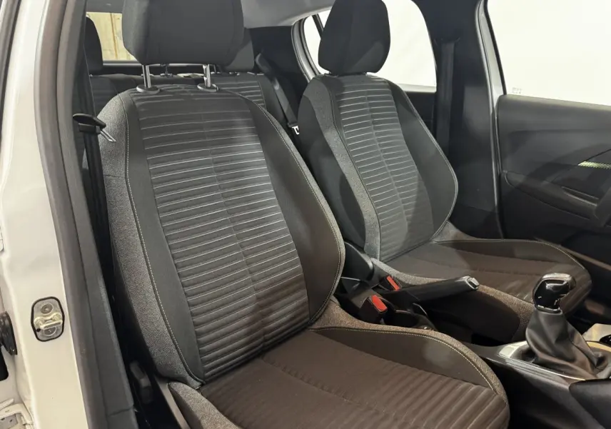 Vue intérieure des sièges avant en tissu noir et gris de la Peugeot 208 PureTech 75 S&S Active blanche, côté droit.