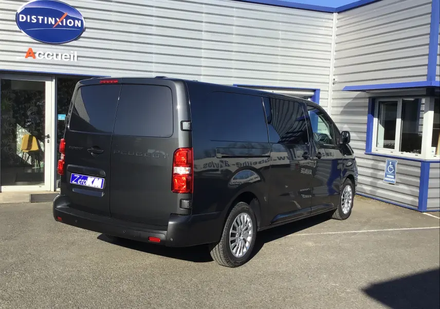 Vue 3/4 avant droite d'un Peugeot Expert Cabine Approfondie gris titane avec calandre noire et jantes argentées.