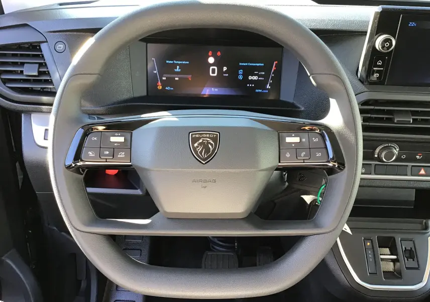 Vue intérieure côté conducteur du Peugeot Expert XL gris titane, montrant les sièges avant et la planche de bord.