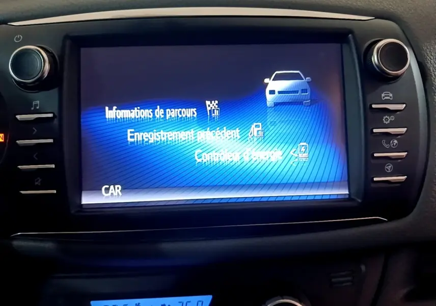 Écran tactile central affichant les informations de parcours dans l'habitacle noir de la Toyota Yaris hybride 2019.