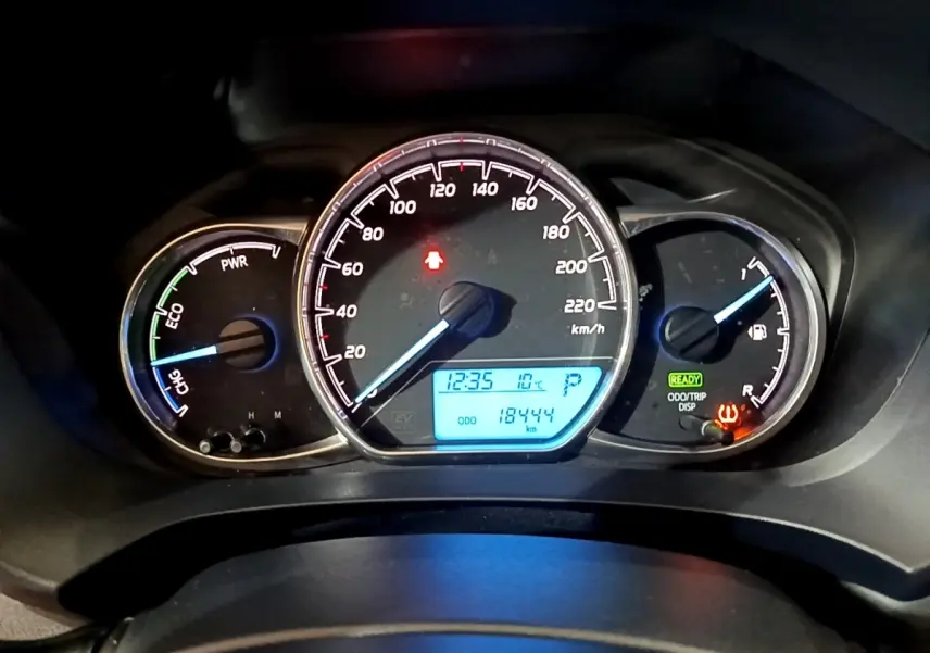 Tableau de bord de Toyota Yaris hybride 2019 montrant compte-tours, vitesse, jauge carburant et affichage digital bleu.