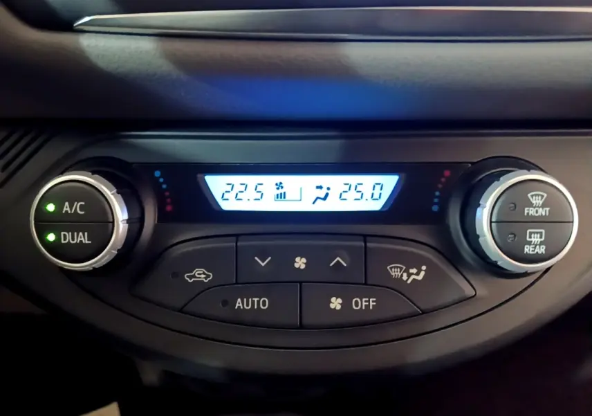 Gros plan sur la commande de climatisation digitale bi-zone de la Toyota Yaris blanche 2019 avec affichage des températures.