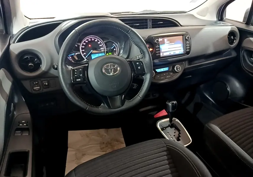 Intérieur de la Toyota Yaris 1.5 Hybrid 2019 vu de face, volant cuir multifonctions et écran tactile central.