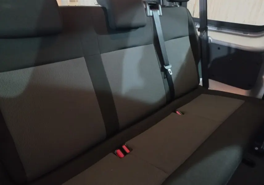 Vue intérieure de la banquette arrière grise du Peugeot Traveller 1.5 BlueHDi 120, avec ceintures et appuie-têtes.