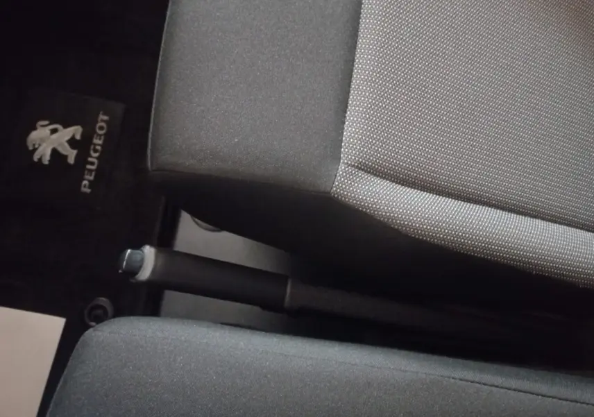 Gros plan intérieur sur le frein à main entre les sièges avant gris foncé du Peugeot Traveller 2021.