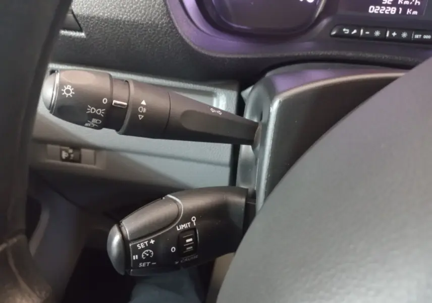 Gros plan sur les commandes au volant du Peugeot Traveller 2021, avec levier de clignotant et régulateur de vitesse.