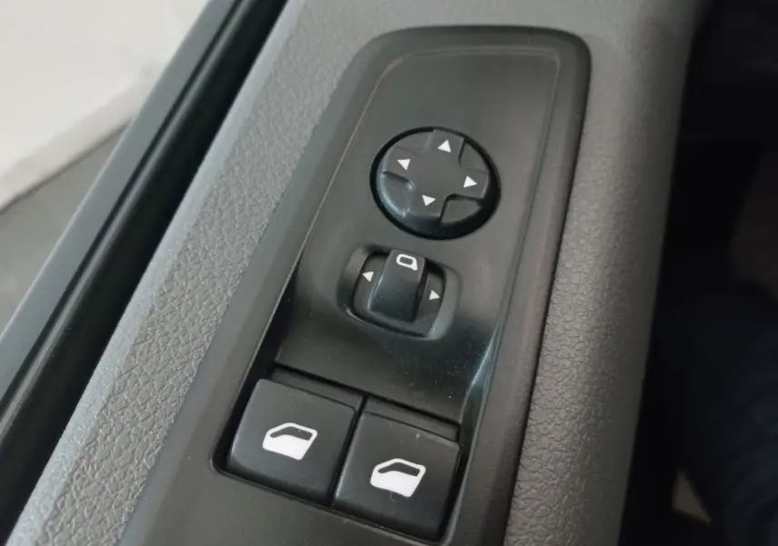 Gros plan sur les commandes de réglage des rétroviseurs et des vitres côté conducteur du Peugeot Traveller gris clair 2021.