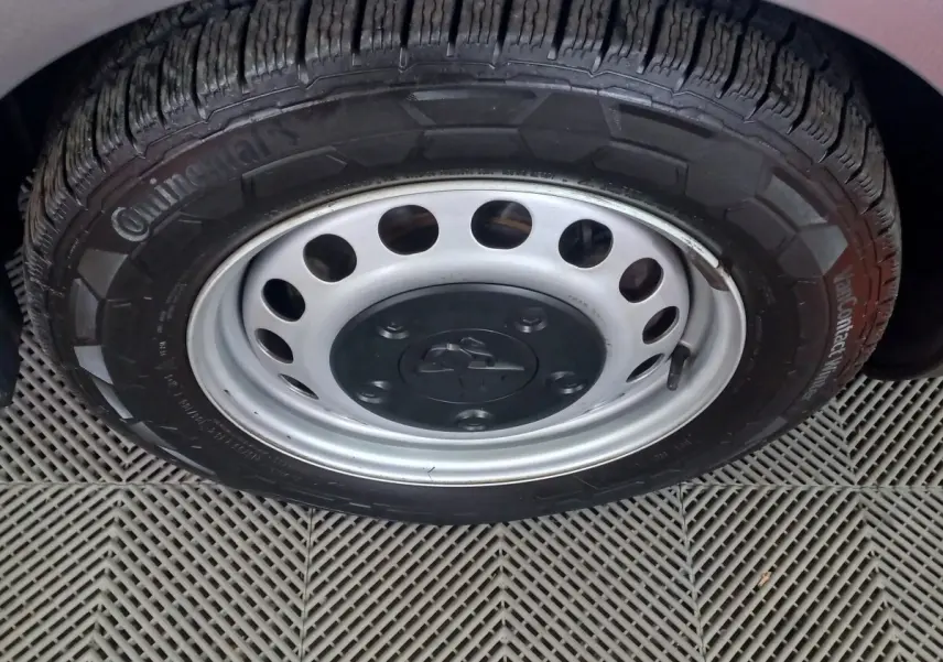 Gros plan sur la roue avant droite du Peugeot Traveller gris clair, mettant en valeur la jante acier et le pneu Continental.