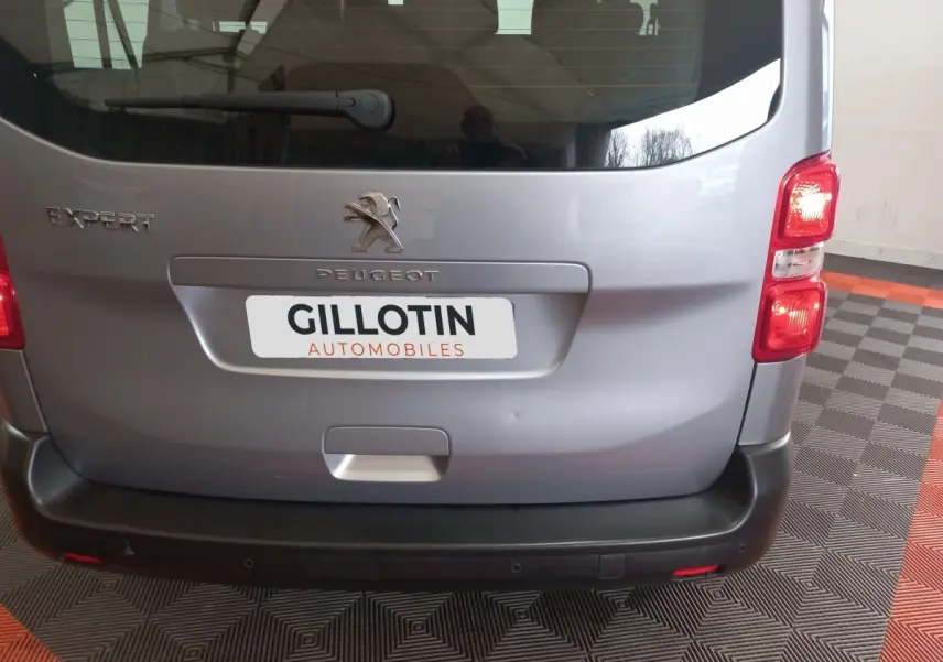Vue arrière d'un Peugeot Expert gris clair avec logo et plaque d'immatriculation GILLOTIN AUTOMOBILES visible.