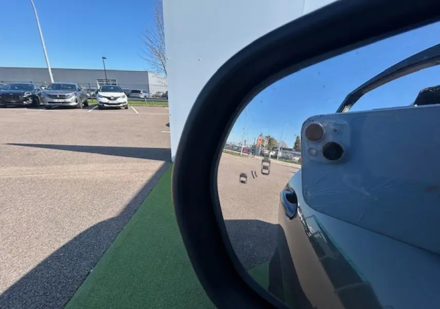 Reflet dans le rétroviseur côté droit d’un Ford Puma gris Magnetic, avec partie de la portière visible.