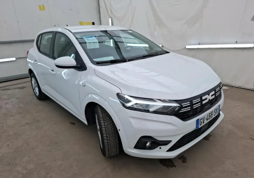 Dacia Sandero blanc vue 3/4 avant droit, avec calandre noire et signature lumineuse LED distinctives.