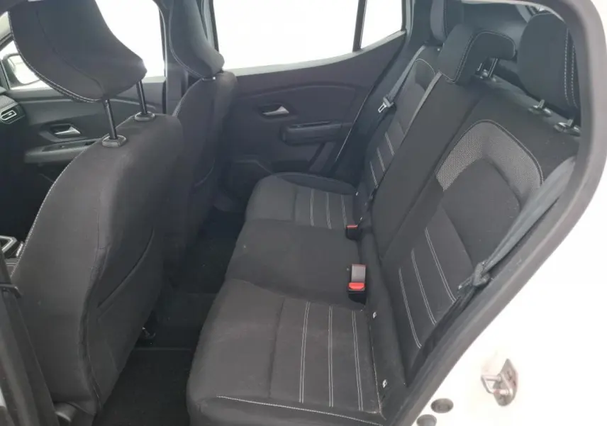 Vue intérieure côté droit sur la banquette arrière noire avec surpiqûres blanches d'une Dacia Sandero blanche 2024.
