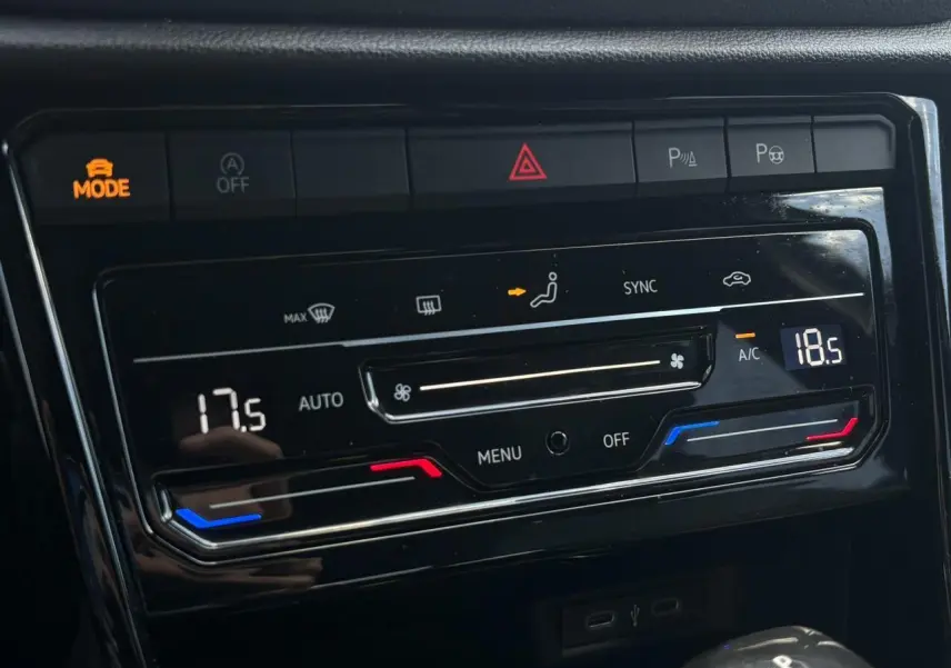 Gros plan sur la commande de climatisation bi-zone du Volkswagen T-Roc noir intense, avec affichage digital et boutons tactiles.