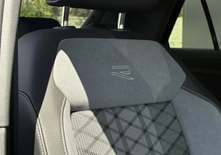 Gros plan sur l’appui-tête avant en cuir et alcantara gris avec logo R-Line brodé, intérieur Volkswagen T-Roc noir.