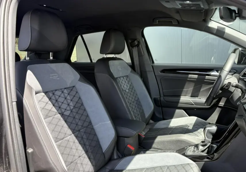 Vue intérieure côté droit des sièges avant en cuir et alcantara gris avec logo R-Line sur un Volkswagen T-Roc noir.