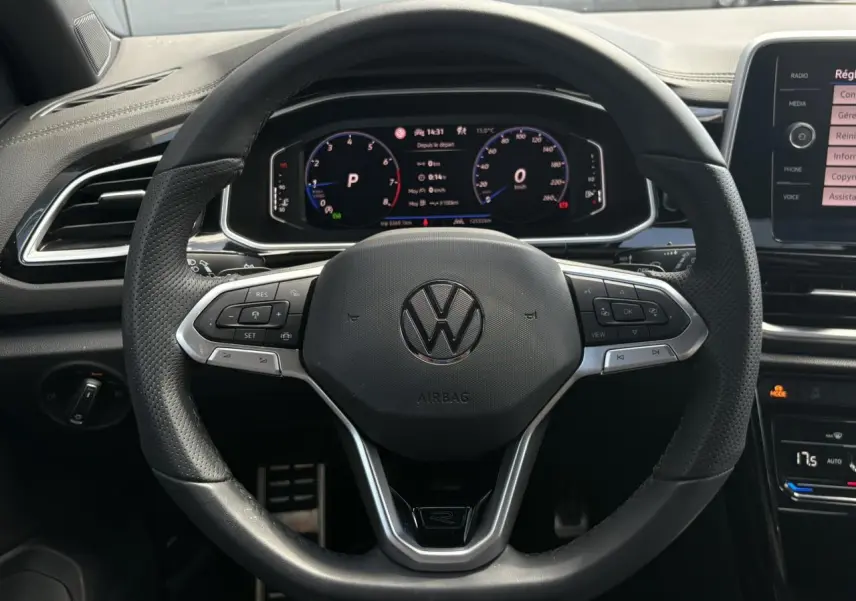 Vue frontale du volant cuir noir R-Line de Volkswagen T-Roc 2025 avec tableau de bord digital et commandes intégrées.