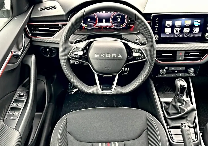 Vue intérieure frontale du poste de conduite du Skoda Kamiq 2026, volant sport et écran tactile multifonction.