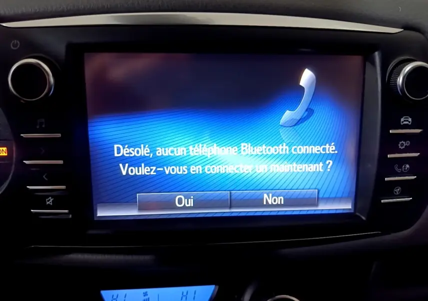 Écran tactile central affichant un message Bluetooth dans l'habitacle d'une Toyota Yaris blanche 2019.