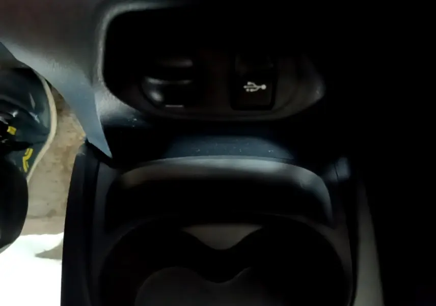 Gros plan sur la console centrale noire de la Toyota Yaris blanche 2019, avec prise USB visible en haut.