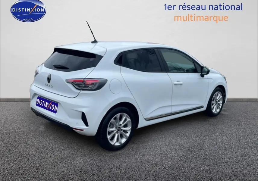 Renault Clio V blanche vue 3/4 arrière droit avec vitres teintées et feux arrière LED allumés.