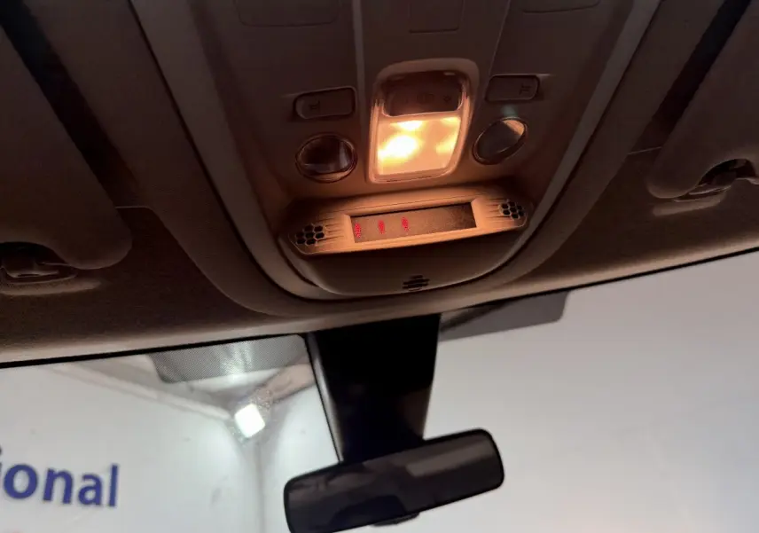 Vue intérieure du plafonnier allumé avec commandes et rétroviseur central d’un Peugeot Rifter blanc 2019.