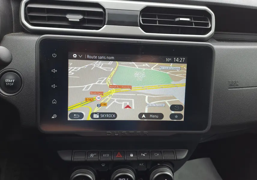Écran central tactile du Dacia Duster 2024 gris urbain, affichant la navigation GPS avec commandes autour.