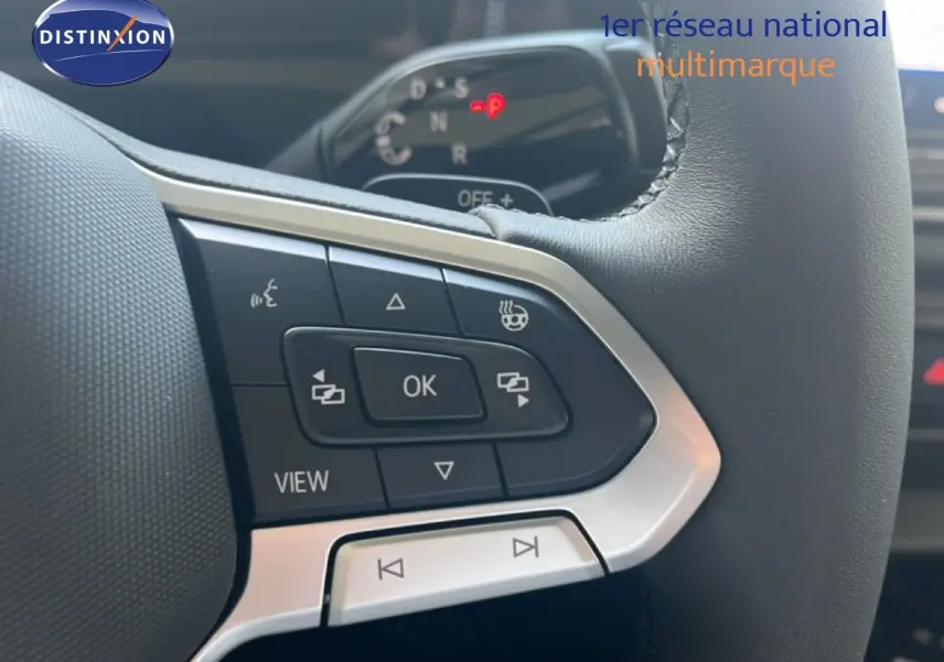 Gros plan sur les commandes au volant en cuir noir du Volkswagen Tiguan 1.5 TSI 130CH DSG Life, avec finition métal argenté.