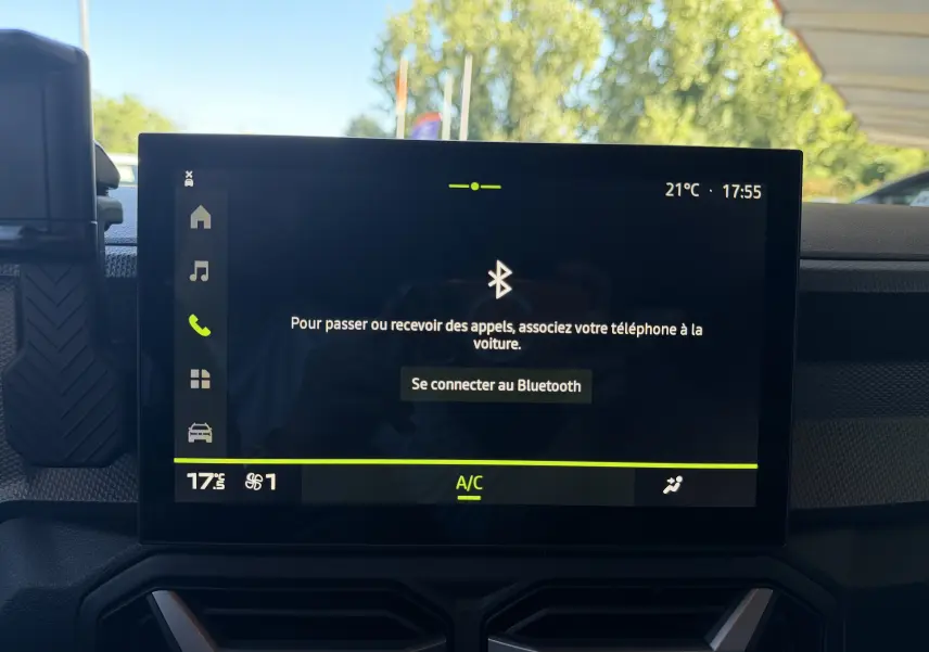 Écran tactile central du tableau de bord du Dacia Duster noir 2026 affichant la connexion Bluetooth et la climatisation.