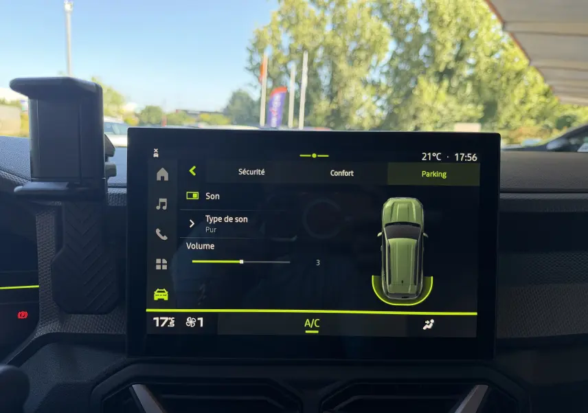 Vue intérieure centrée sur l'écran tactile du tableau de bord du Dacia Duster Hybrid 155 Journey, affichant l'interface de parking.