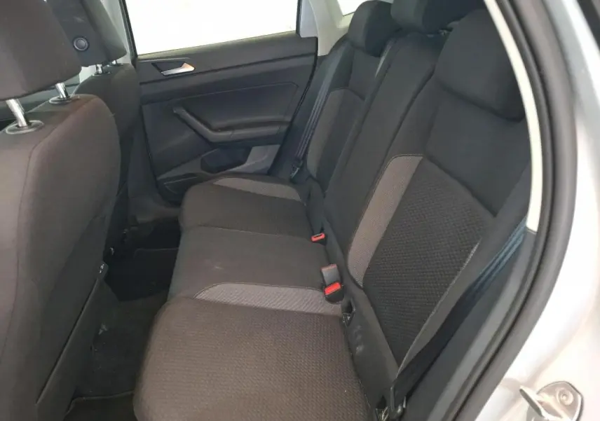 Vue intérieure côté droit de la banquette arrière en tissu gris foncé de la Volkswagen Polo 2024 gris clair.