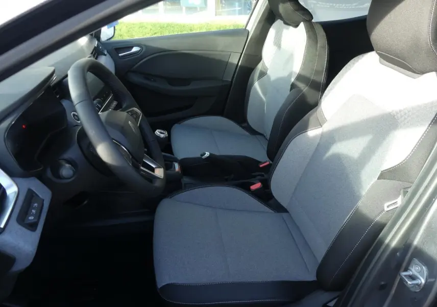 Vue intérieure côté conducteur de la Renault Clio gris schiste 2025, sièges tissu gris à motifs 3D twida.